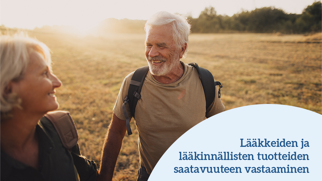 Iäkäs mies ja nainen katsovat toisiaan nauraen ilta-auringossa pellolla.